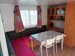 Un comedor con una mesa y sillas y un sofá. en Mobil home LA BAULE 437, en La Baule