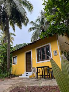 a yellow house with a table and chairs in front of it at Cute Studio at Portuguese Villa by Goaround Homes in Anjuna