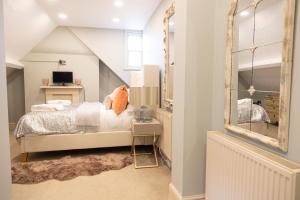 a bedroom with a bed and a mirror at Vale House, Belvoir Castle in Grantham