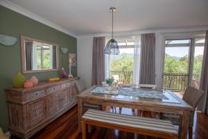 a dining room with a table and a balcony at Cypress Lakes Villa Domenica in Pokolbin