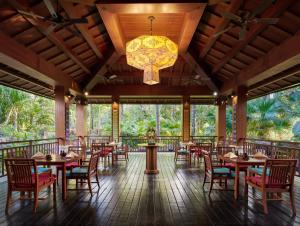 a restaurant with tables and chairs and a chandelier at InterContinental Xishuangbanna Resort by IHG in Jinghong