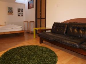 プラハにあるAttic Apartment City Centerのリビングルーム(革張りのソファ、ラグ付)