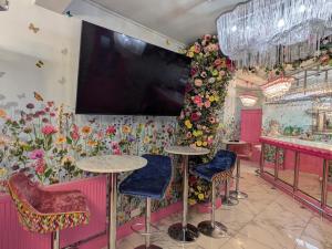 a restaurant with two tables and a large tv on the wall at Vale House, Belvoir Castle in Grantham