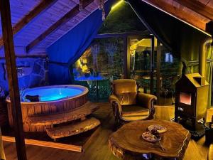 a living room with a tub and a chair and a table at Hoşdere Bungalov in Çamlıhemşin