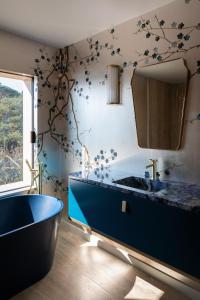 a bathroom with a blue tub and a mirror at Villa Le Levant in Mandelieu-la-Napoule