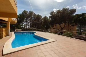 カステルデフェルスにあるApartamento en castelldefelsの建物の隣のパティオにスイミングプールがあります。