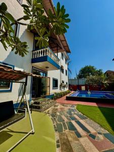 ヴァガトールにある1BHK Apartment at Honeydew 1 by Goaround Homesのプールと家のあるヴィラ