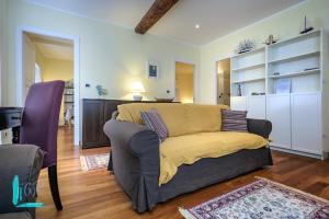 a living room with a couch with a yellow blanket at Casa Minni in Boccadasse in Genoa