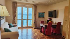 a living room with a table and red chairs at Scarlet Flower - Lago Maggiore in Meina