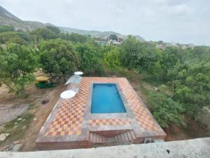 A piscina localizada em Jhalana Retret Rooms ,Farm ,Pool, Mountain view ou nos arredores