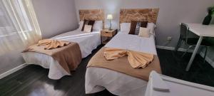 pokój hotelowy z dwoma łóżkami i umywalką w obiekcie Casa de Huéspedes con encanto El Sueño del Quijote w mieście Alcalá de Henares