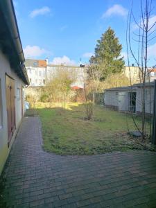 a brick walkway next to a yard with buildings at Monteure und Pendler willkommen! Komfortable 2 Zimmer Apartments in der Innenstadt in Neumünster