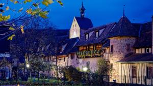 duży kamienny budynek z wieżą zegarową w obiekcie Remparts de Riquewihr - Refuge du Lutin - Studio w mieście Riquewihr