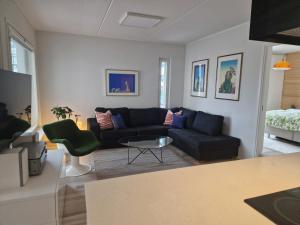 un salon avec un canapé noir et une table dans l'établissement Bright, big apartment with own sauna & balcony, à Helsinki