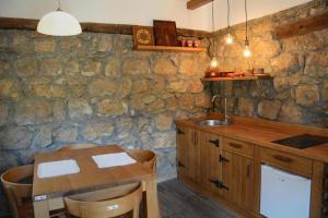 eine Küche mit einem Holztisch und einem Spülbecken in der Unterkunft Serbina in Kandalica