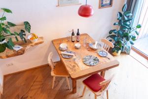 a wooden table with chairs and wine bottles on it at Ecologie Grundlsee in Grundlsee