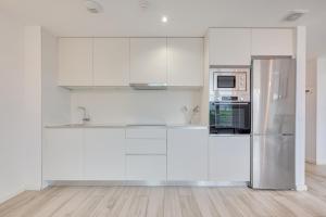 a kitchen with white cabinets and a stainless steel refrigerator at Ripa by Clabao in Burlada