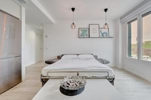 a white bedroom with two beds and a table at Ripa by Clabao in Burlada +24 photos