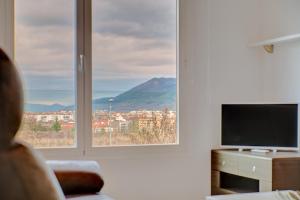 a person sitting in a living room looking out a window at Ripa by Clabao in Burlada