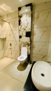 a bathroom with a toilet and a sink at Shree Anantay Club & Resort in Ujjain +14 photos