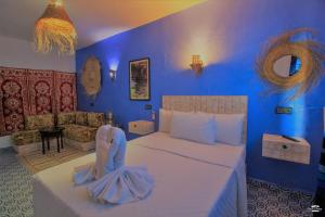 a bedroom with a bed and a blue wall at CASA TROUSSI in Chefchaouene
