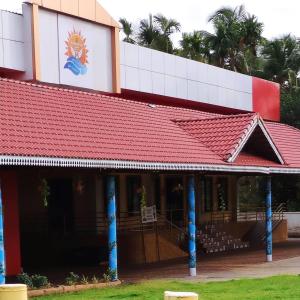 a red roofed building with a red roof at Ashirvad Villa Rooms in Kotikulam