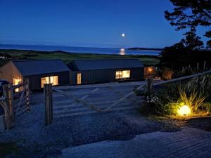 a house with a fence and a gate at night at Nautilus Tenby in Tenby