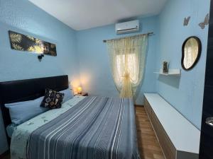 niebieska sypialnia z łóżkiem i oknem w obiekcie Apartment la paz w Madrycie