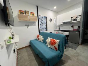 salon z niebieską kanapą z poduszkami w obiekcie Apartment la paz w Madrycie