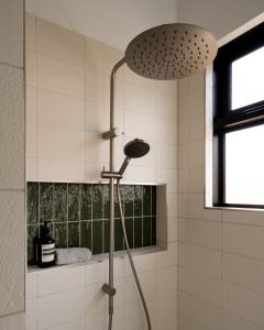 a shower in a bathroom with white tiles at Casa Mia Blackheath in Blackheath +15 photos