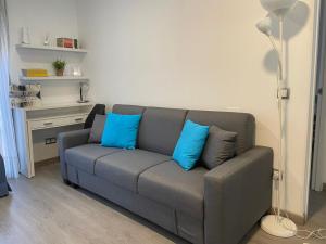 a gray couch with blue pillows in a living room at Apartamento El Hidalgo in Alcalá de Henares