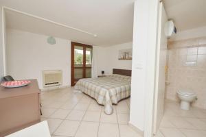 a bedroom with a bed and a bathroom with a toilet at Pineta Azzurra in Marina di Grosseto +280 photos