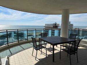 a table and chairs on a balcony with the ocean at Sky Residence in Lignano Sabbiadoro