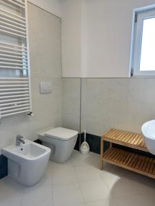 a white bathroom with a toilet and a sink at Sky Residence in Lignano Sabbiadoro