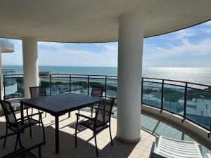 a table and chairs on a balcony with the ocean at Sky Residence in Lignano Sabbiadoro +4 photos