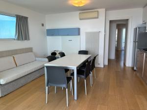 a living room with a couch and a table and chairs at Sky Residence in Lignano Sabbiadoro