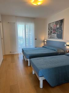 a room with three beds in a room at Sky Residence in Lignano Sabbiadoro