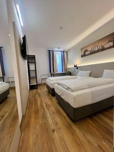 a hotel room with two beds and a television at Plaza Inn Berlin Süd Ludwigsfelde in Ludwigsfelde