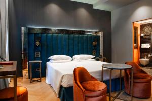 a bedroom with a large bed with two chairs at Hotel Campiello in Venice