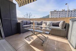 un divano e un tavolo sul balcone di Les Vergers - Calme, Piscine, Parking & Terrasse a La Valette-du-Var