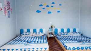 two beds in a room with blue at Thủy Trúc Home - Đảo Phú Quý in Cu Lao Thu