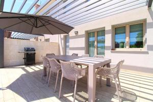 a patio with a table and chairs and an umbrella at Elegant villa with private pool in Bale in Bale