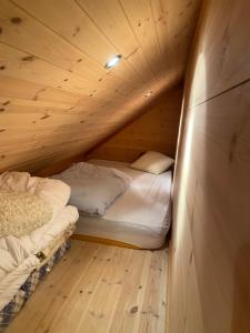 a room with two beds in a wooden cabin at Moderne Rorbu helt i sjøkanten in Hauge