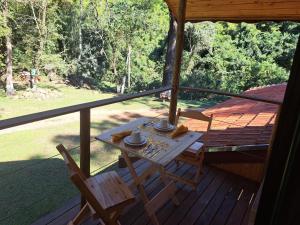 a table and a chair on a porch at Recanto Do Sapucaí in Sapucaí-Mirim