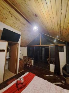 a room with a bed and a wooden ceiling at Recanto Do Sapucaí in Sapucaí-Mirim