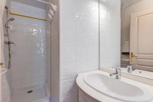 a white bathroom with a sink and a shower at Le Chevreuil - 3 chambres, terrasse, piscine in Flumet +9 photos