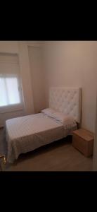 a small bedroom with a bed and a window at Increible apartamento en primera linea de playa in Puerto de Gandía