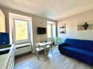 a living room with a blue couch and a table at Dal Comandante by Arbaspàa in Manarola
