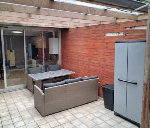 eine Backsteinwand mit 2 Stühlen und einem Tisch in der Unterkunft Gelijksvloers Vakantieappartement 2 slaapkamers in Blankenberge