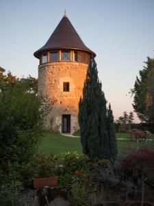 un bâtiment avec une tour au milieu d'un jardin dans l'établissement Le Moulin de Margaux, à Margaux